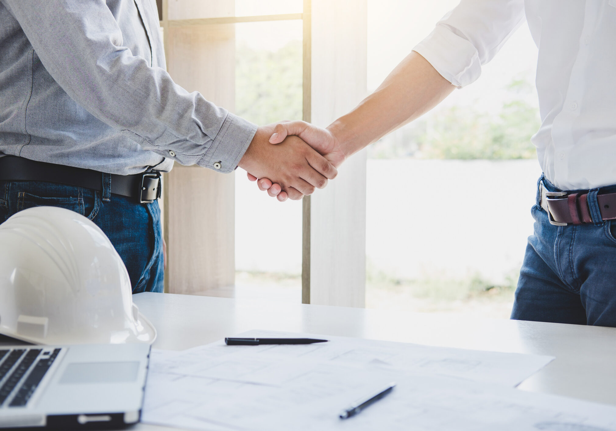 Two engineer or architect meeting for project, handshake after consultation and conference new project plan, contract for both companies, success, partnership.